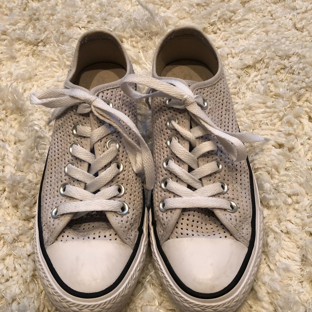Perforated Converse tennis shoes.